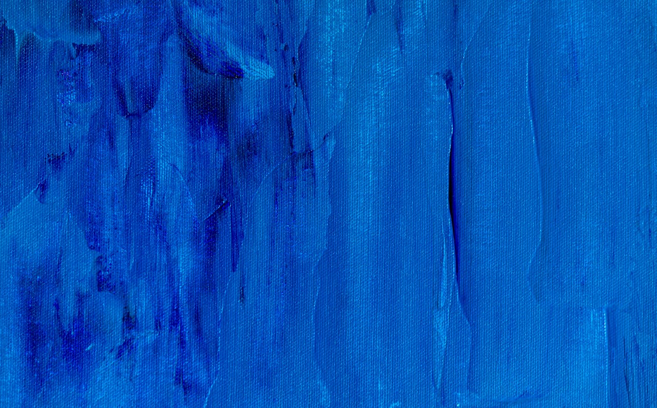 A close-up of a vibrant blue abstract painting with rich textures on canvas.